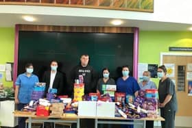Big Ryan (centre) with Scott Benton (second left) and staff from The Harbour, with the huge haul of goodies