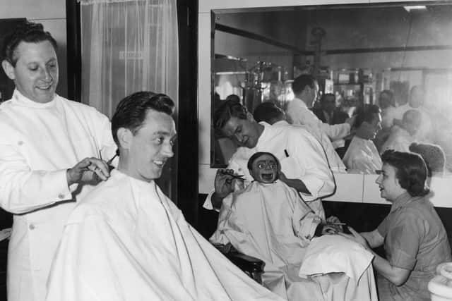 Arthur Worsley stops into a barber's shop in London's Strand for a trim. Meanwhile his dummy, Charlie Brown, demands the full treatment, with a haircut and manicure.  Photo: Getty Images