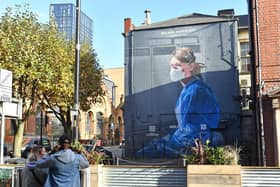 A mural depicting a health worker by artist Peter Barber in Manchester