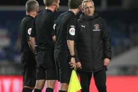 Neil Critchley speaks with the match officials after Tuesday's defeat to Wimbledon