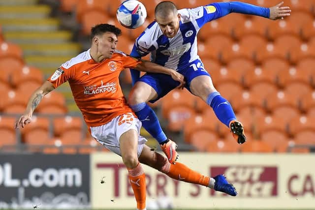Daniel Gretarsson contests a high ball with Wigan's Joe Garner during Blackpool's ugly victory