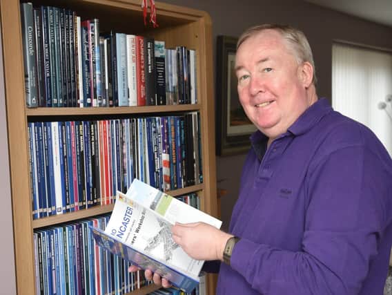 Mark Waites with a book case full of Haynes manuals at his Fleetwood home