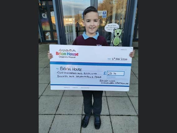 Bailey Wood hands his donation over to Brian House Children's Hospice