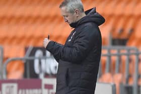 Neil Critchley scribbles down some notes during Blackpool's victory against Portsmouth last night