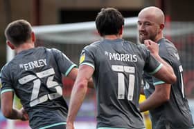 Fleetwood players congratulate Paddy Madden (right) on his record-equalling winner at Swindon