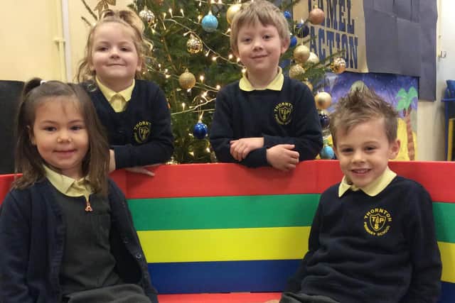 Year One pupils Charlie Lord, Penelope Lovatt, Harry Gearing and Henry Berry enjoy their new buddy bench, which was donated to Thornton Primary School by McCarthy and Stone retirement property builders.
