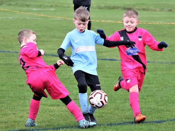 Action from CN Sports Tangerines (centre) v FC Rangers at Common Edge