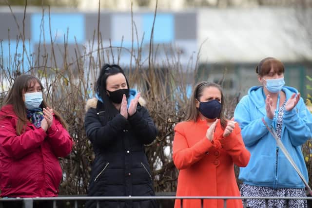 Mourners raise their hands in applause for Cath Strangwood, a school worker at Moor Park, as her funeral cortege passed. Mrs Strangwood died in hospital after battling coronavirus. Photo: Daniel Martino for JPI Media