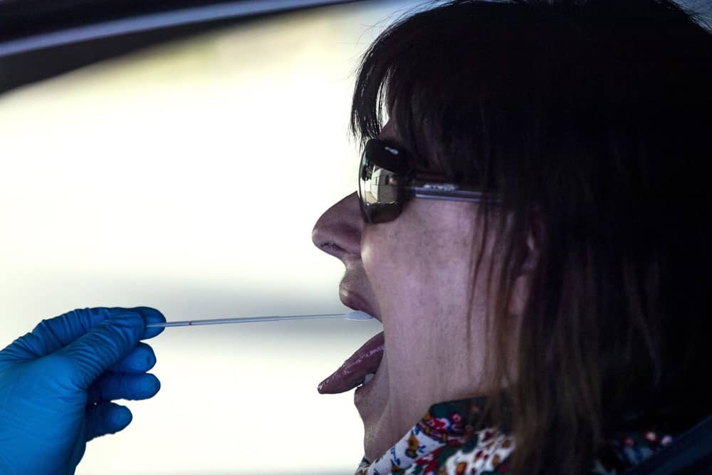 A woman undergoes a PCR throat swab (AP Photo: Manu Fernandez)