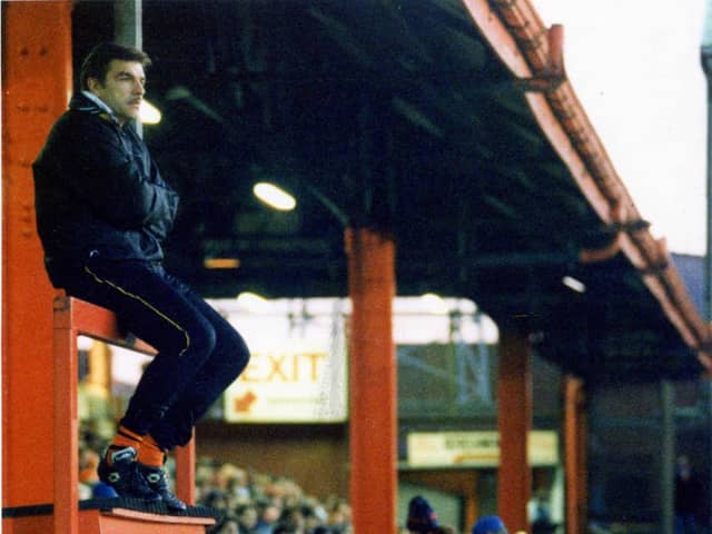 Sam Allardyce sitting atop of the Bloomfield Road dugout