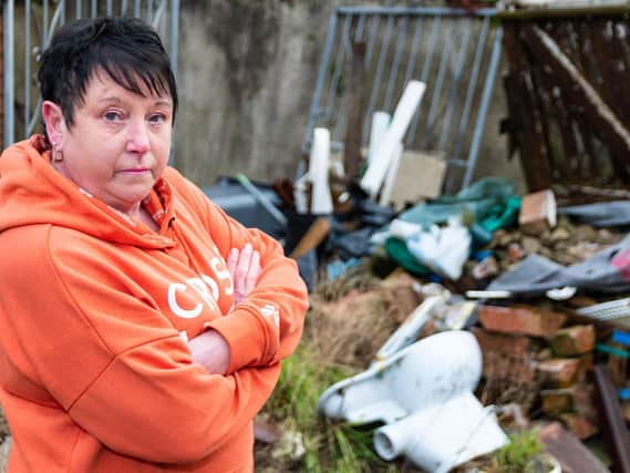 Jeanette Hyde outside the rear of 95 Saville Road in Blackpool, which the rubbish that has been dumped in the back yard. Photo: Kelvin Stuttard