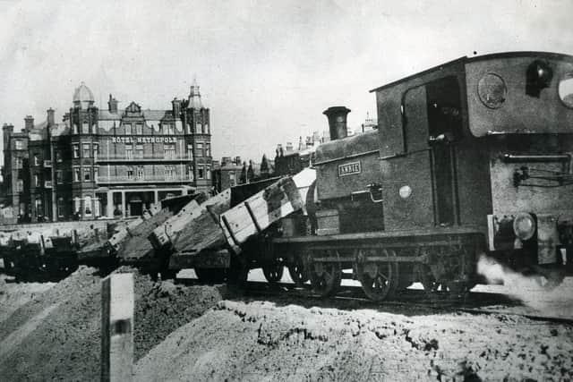 Tipping the sand ready for shovelling by an army of workmen