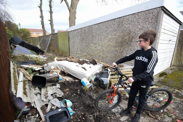 Residents off Saltash Road in Thornton want Wyre and Lancashire County Councils to help resolve the fly-tipping and potholes in the area. Pictured is Isaac Anderton, 10.