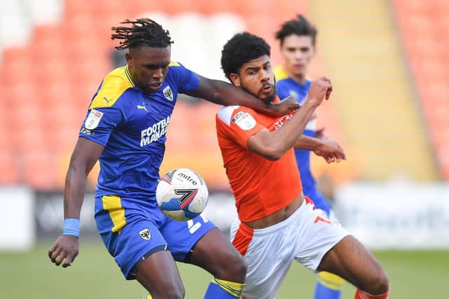 Ellis Simms battles for the ball with Wimbledon's Darnell Johnson during Saturday's drawn game at Bloomfield Road