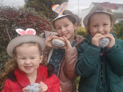The Mawdsley sisters, Mollie, four, Delilah, eight (middle) and Eva Jean, seven, have been leaving rocks with rainbows and positive messages on their neighbours' doorsteps. Photo: Karen Feather