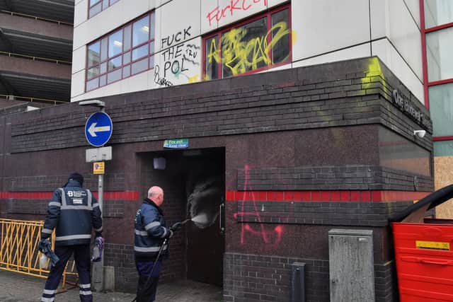 Workers from the Bristol BID Team clean graffiti outside of Bridewell Police Station in Bristol. Protesters broke windows and vandalised the police station on Sunday after demonstrating against the Government's controversial Police and Crime Bill.