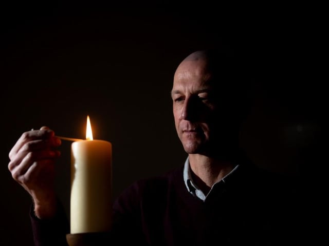 Dr Jason Cupitt, who is in charge of Blackpool Victoria Hospital's Covid intensive care unit, lights a candle in the hospital's chapel to remember the pandemic's victims (Picture: Dan Martino for JPIMedia)
