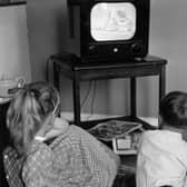 Children watch an early TV set in 1957. Picture: Getty Images
