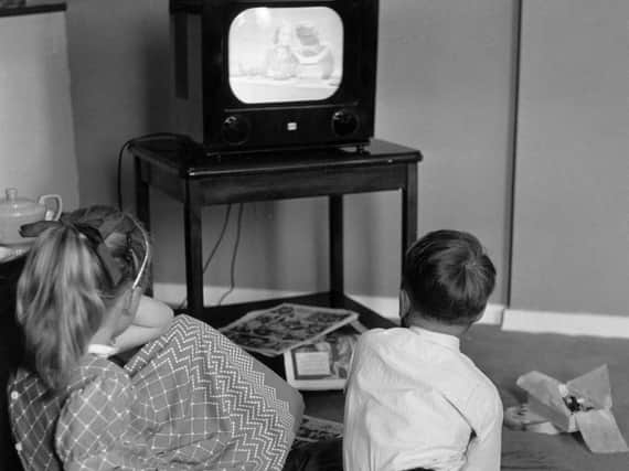 Children watch an early TV set in 1957. Picture: Getty Images