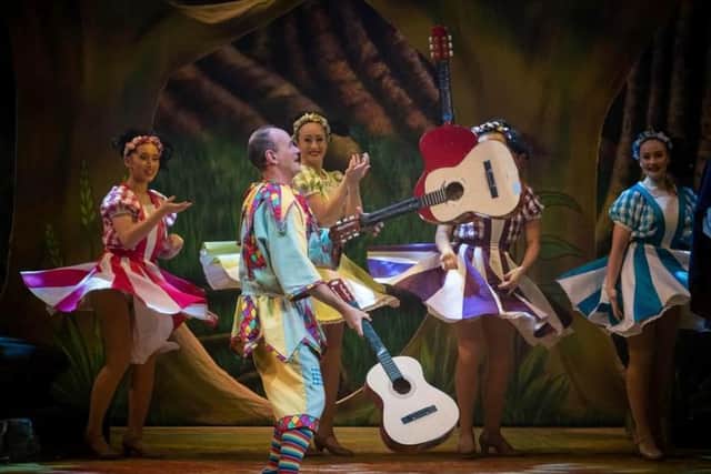 Steve Royle juggles guitars during Blackpool Grand Theatre's production of Snow White and the Seven Dwarves