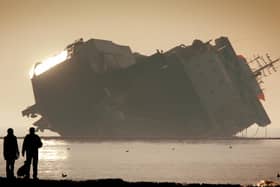 An atmospheric shot of the Riverdance with silhouette figures in the foreground and the sunlight glistening on the side of the doomed vessel