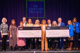Yvonne Ball presents the cheques for £57,500 each to the two charities, with Bobby Ball Foundation trustees looking on