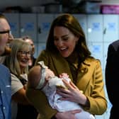 The Duchess of Cambridge holds Anastasia Barrie in her arms while her parents, Trudi and Alastair watch with pride.