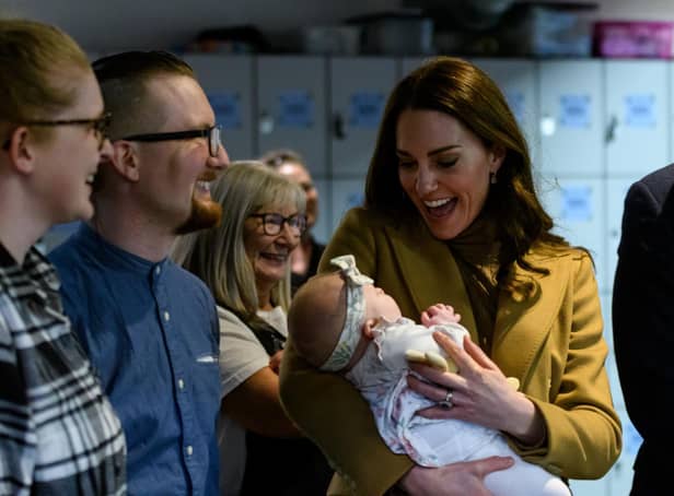 The Duchess of Cambridge holds Anastasia Barrie in her arms while her parents, Trudi and Alastair watch with pride.