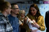 The Duchess of Cambridge holds Anastasia Barrie in her arms while her parents, Trudi and Alastair watch with pride.