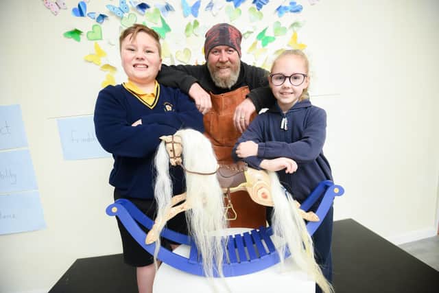 A wooden rocking horse is being auctioned to raise money for a special memorial garden at Larkholme Primary. Pictured is Kev Gray who made the horse with pupils Jamie Hay and Louisa Beech.