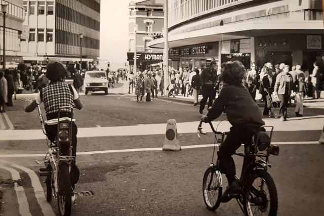 These two lads are riding down Church Street on their bikes. This is outside The Grand Theatre.