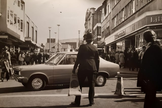 Littlewoods, Timpsons and a sign for Alexandra Clothing are pictured in this photo. The police officer looks like he was moving traffic cones. At the time road works were going on in Church Street