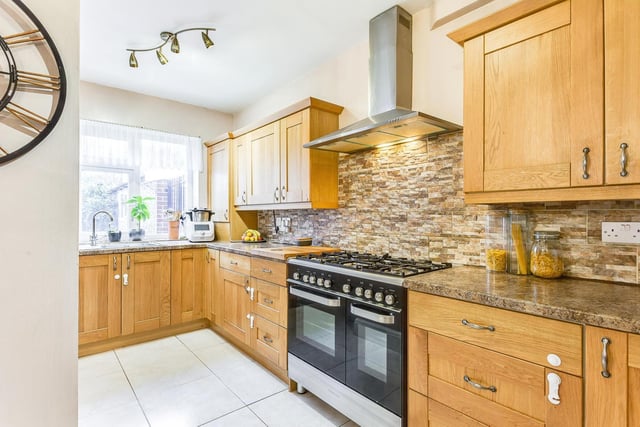 The modern kitchen has contemporary wooden units and plenty of worktop space to cook.