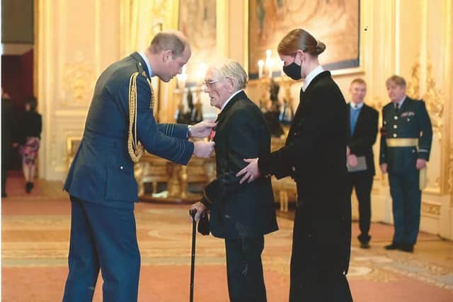 Charles receiving his MBE from Prince William, the Duke of Cambridge