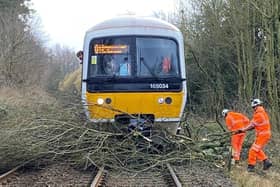 Workers clearing branches of a tree from the tracks after Storm Eunice