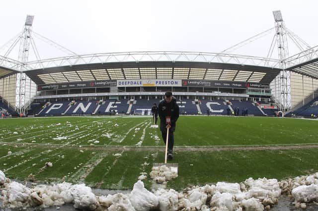 Snow is cleared from the Deepdale pitch ahead of PNE's game against Reading