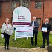 Nigel Dunnington centre hands over the money raised to Trinity Hospice