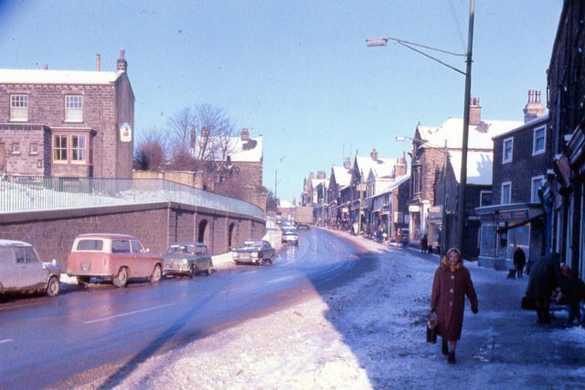 Lower Town Street with Stocks Hill on the left pictured in February 1969. Proctor's, china, hardware and ironmongery retailers, can be seen with the green sign, beyond this is Patchett's Place. All the property on the right was demolished for the building of Bramley Shopping Centre.