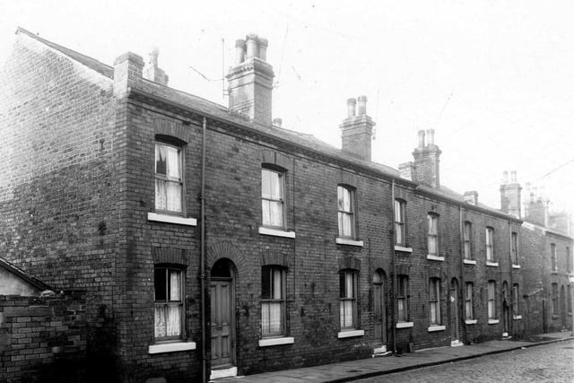 Alton Place in December 1960. Four double fronted back-to-back terraced houses flanked by shared outside toilet blocks. Families were to be relocated as part of slum clearance plans.