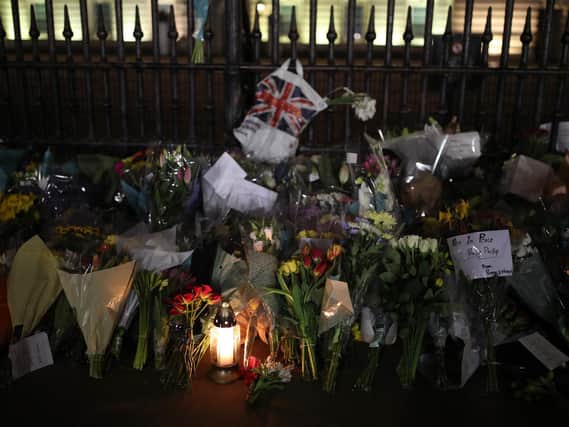 Floral tributes and candles are left outside Buckingham Palace, London, following the announcement of the death of the Duke of Edinburgh at the age of 99. Picture date: Friday April 9, 2021. Picture: PA Wire/PA Images/Yui Mok