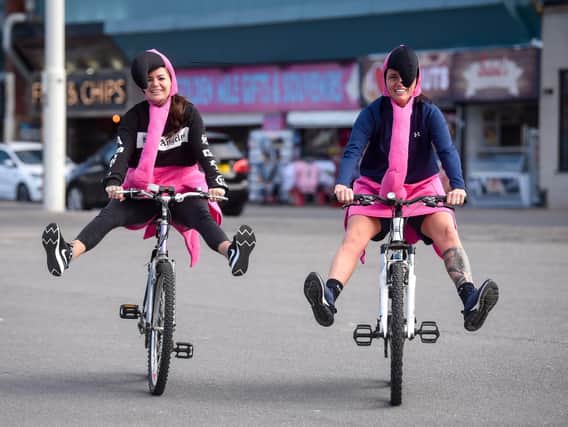 Stefi Jefferson and Jodie Reynolds are cycling dressed as pink flamingos to raise money for Stefi's sister Michelle.