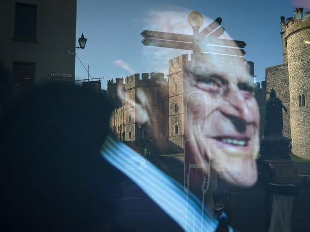 Windsor Castle is reflected in a shop window displaying a photograph of Prince Philip, Duke Of Edinburgh who died aged 99 on April 15, 2021 in Windsor