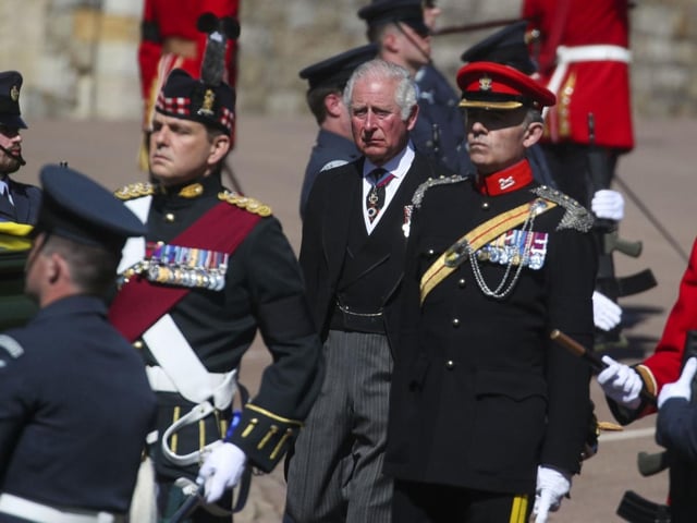 The Prince of Wales stands behind the Land Rover Defender carrying the coffin of the Duke of Edinburgh upon its arrival at the Galilee Porch of St George's Chapel, at Windsor Castle, Berkshire, during his funeral