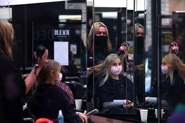 A customer has her hair dried following a haircut inside a hairdresser's salon in London