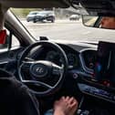 A picture taken on April 15, 2021 shows engineer Alexey keeping his hands on his knees as the self-driving car, developed by Russian internet giant Yandex, moves along a road in Moscow