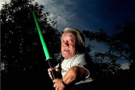 R2D2 actor Kenny Baker poses at his home in Preston with a light sabre for the 30th anniversary of the release of Star Wars: A New Hope