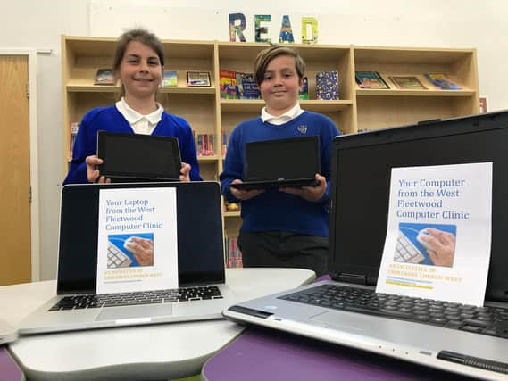 Head girl Sophia Cox and head boy Matthew Foley at Poulton St Chad’s Primary School with some of the newly refurbished laptops
