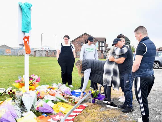 People lay flowers and cards at Common Edge playing fields today