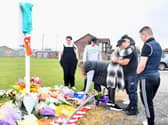 People lay flowers and cards at Common Edge playing fields today