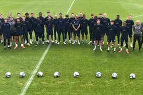 Blackpool players and staff stand behind nine footballs in silent tribute to Jordan Banks